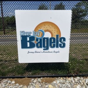 a sign hanging on a baseball field outfield fence