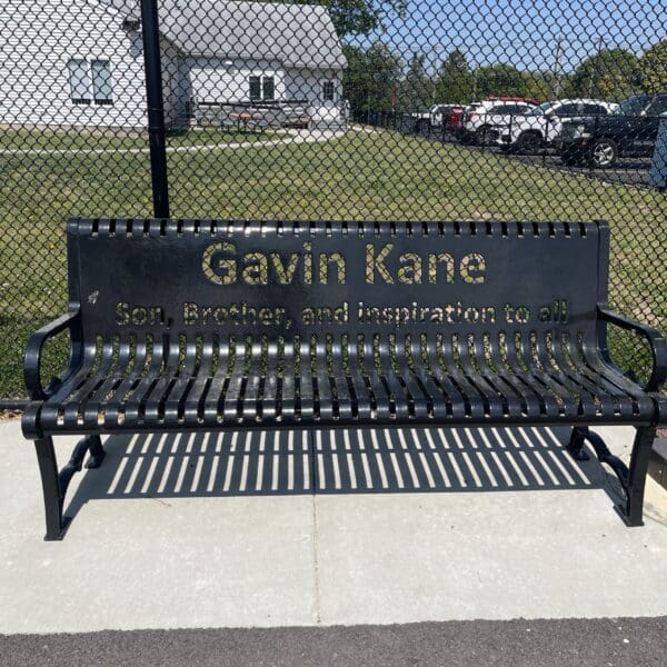 photo of a metal bench with a name on it