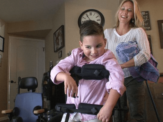trfod-3 Gavin Kane, 6, who has a severe brain trauma from a car accident five years ago, prepares to head outside with his mom Mary at their Toms River home